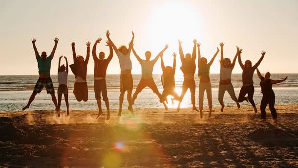 Schülergruppe am Strand im Gegenlicht